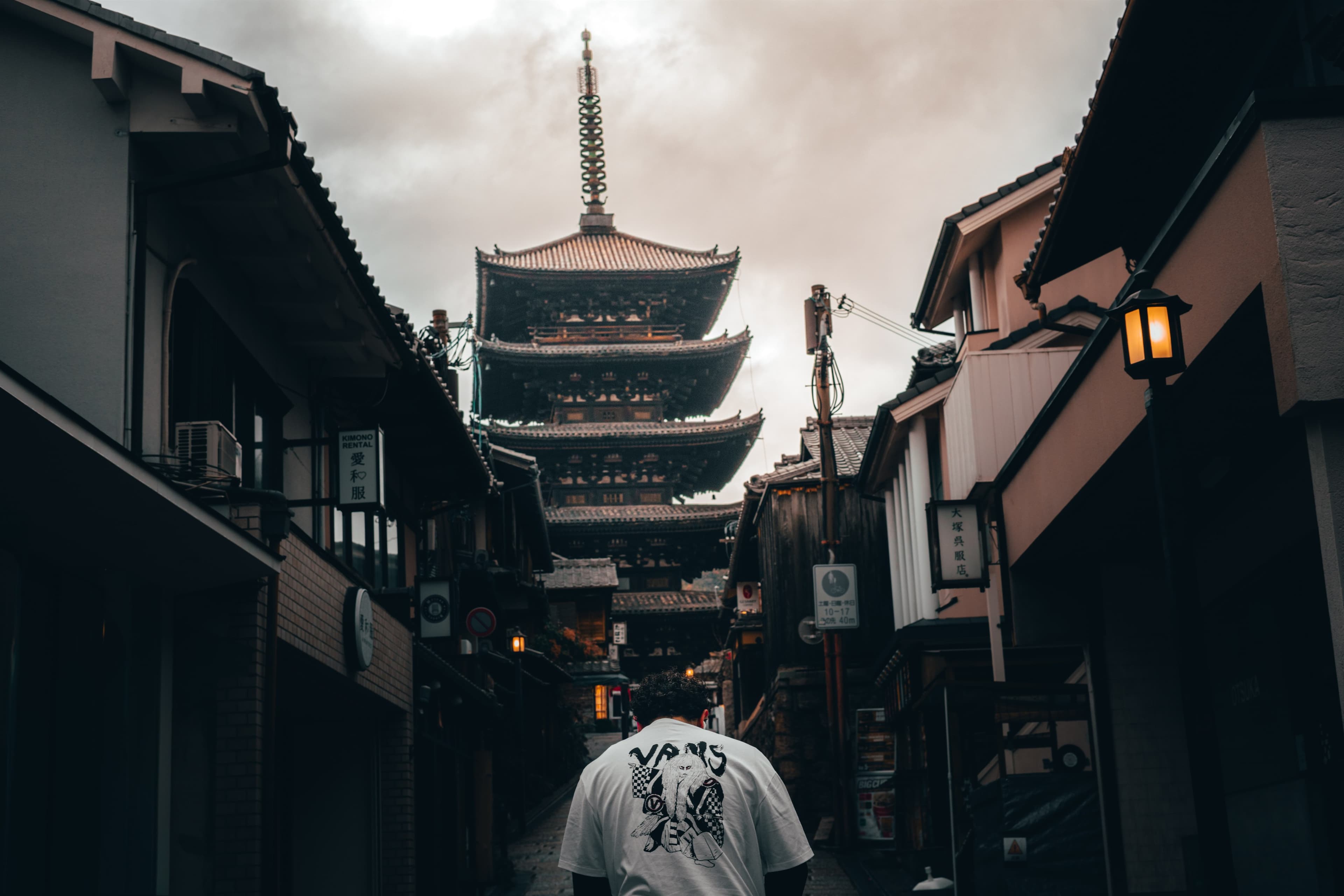 Walking toward the Yasaka Pagoda through Kyoto's Higashiyama district at dusk.