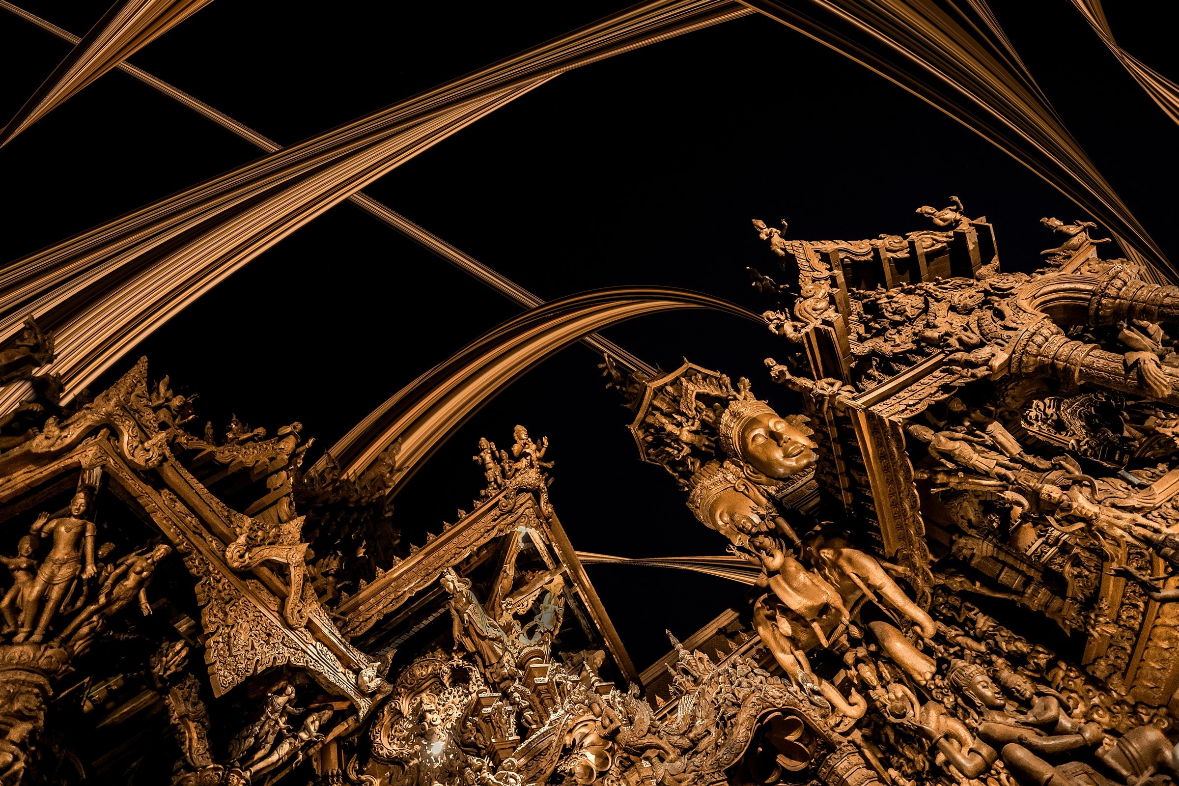 An ornately carved golden wooden facade against a black night sky, streaked with pixel-stretch distortion.