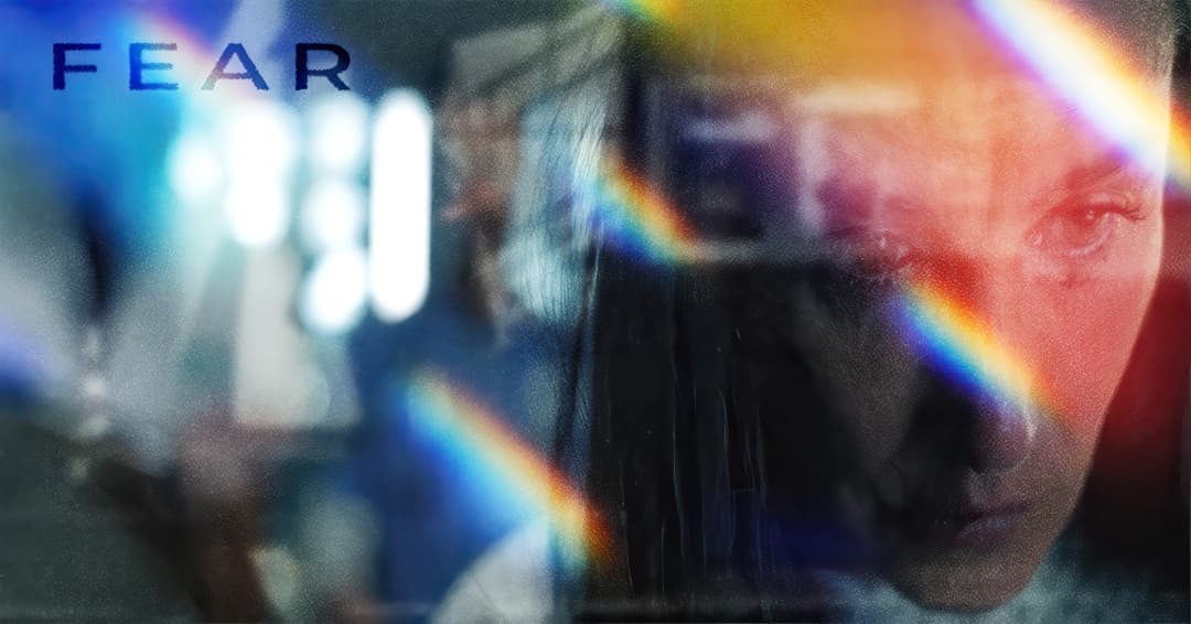 A prism light-leak overlay across a tearful close-up face, titled 'FEAR.'